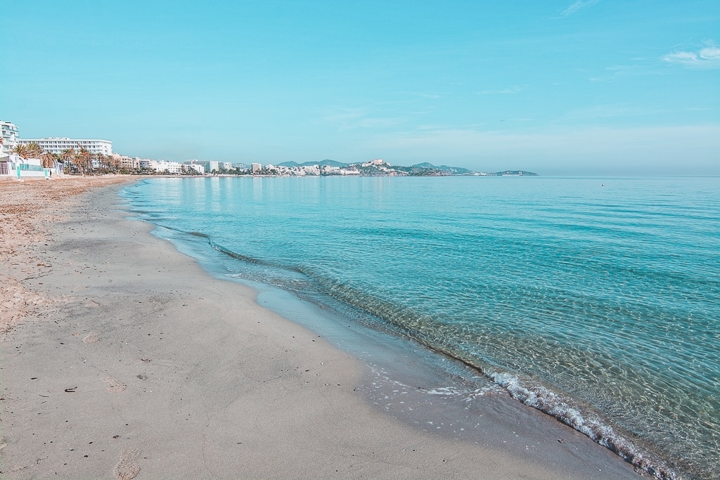 Empty beautiful sandy Playa d'en Bossa beach on a sunny and misty winter morning in December in Ibiza, Spain.